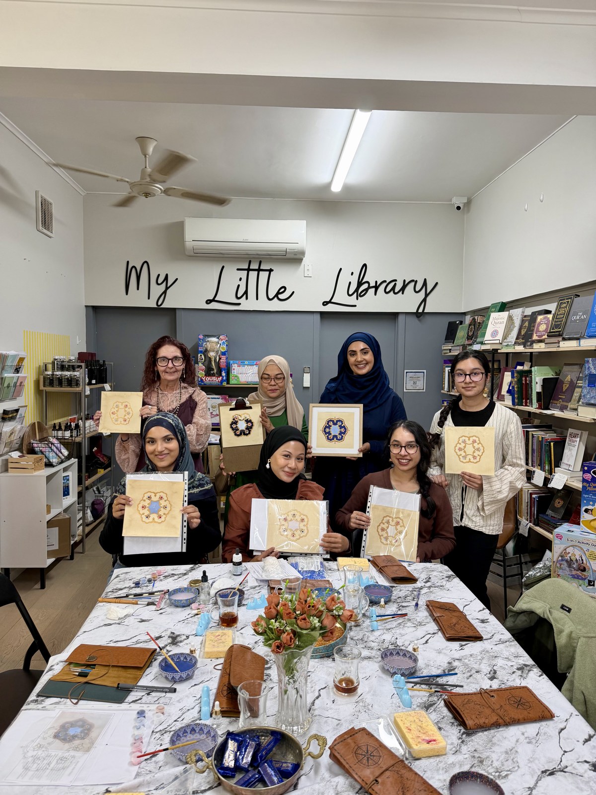 A group of workshop participants displaying their artworks together
